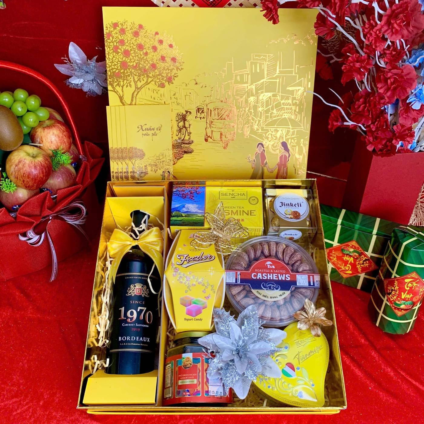 Hộp quà Tết mở nắp: chai vang đỏ Bordeaux cùng trà, socola, hạt điều và mứt